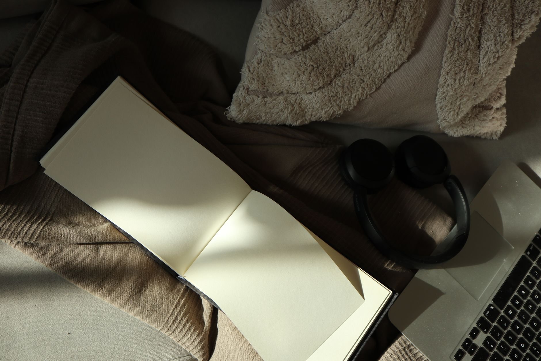 A warm, minimalist flat lay of an open notebook with soft lighting — representing a considered, intentional creative process