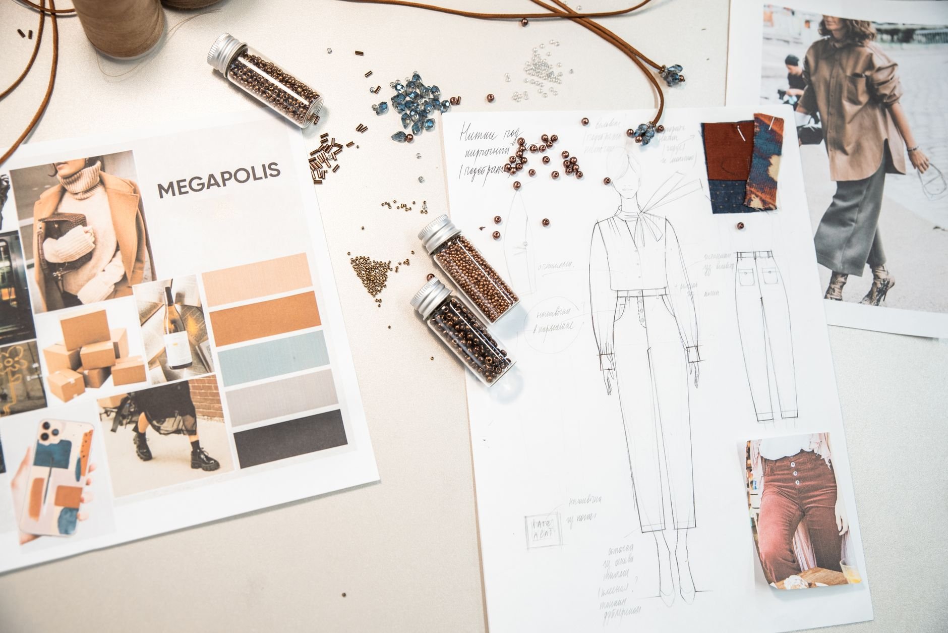 Creative fashion workspace featuring design sketches, mood boards, and visual references on a desk